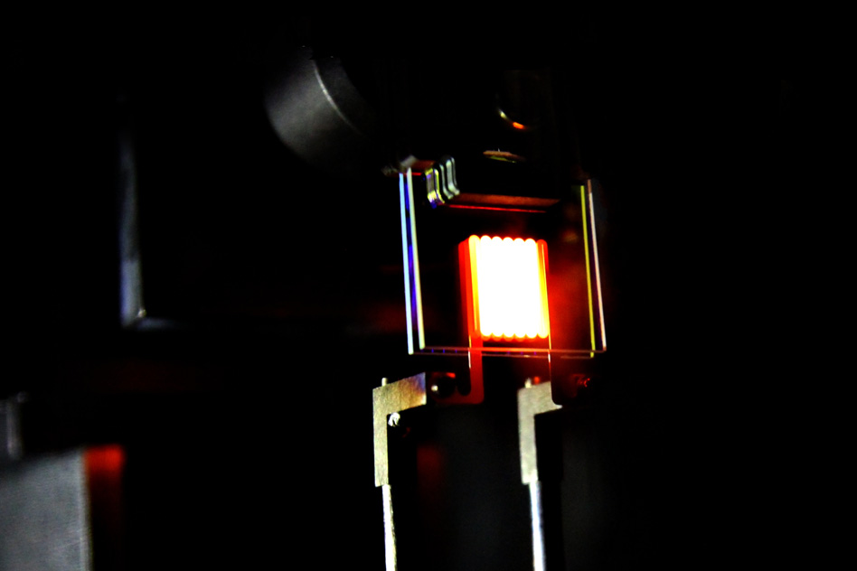 Forsøg med et glødende legeme mellem to lag krystal der fungerer so gennemsigtigt varmespejl (MIT).